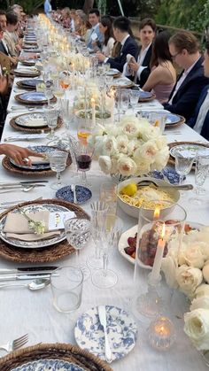 a long table is set with plates and flowers