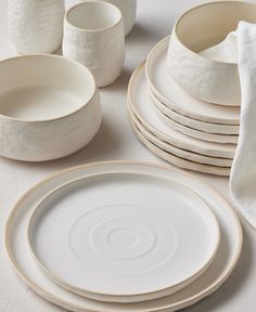 a table topped with white plates and cups