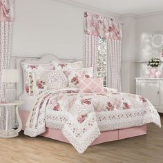 a bed with pink and white comforters in a room