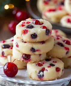 cherry shortbread cookies stacked on top of each other with cherries in the background