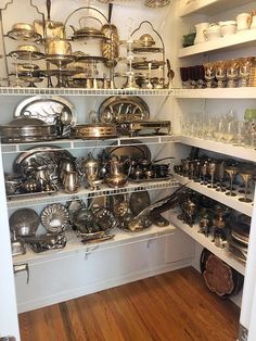 the shelves are filled with many different types of pots and pans, including silverware