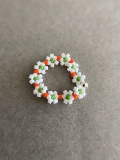 Beaded stretch Flower Ring - White, Orange, Green Color : White, Orange, Green Size : about 20mm Ring Size : one size ( fit for size 6 to 7 ) Materials : Seed bead, Acrylic bead * Metal components seed bead, acrylic bead. * Comes in a jewelry box. If you need extra boxes for gifting....just let us know! White Flower Ring For Spring Gift, White Flower Ring For Spring, Spring White Flower Ring As A Gift, Spring White Flower Ring, Handmade White Flower Ring For Spring, Handmade Adjustable White Flower Ring, Adjustable Handmade White Flower Ring, Adjustable White Flower Shaped Ring, Adjustable White Handmade Flower Ring