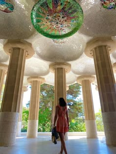 a woman is standing in the middle of columns