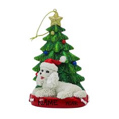 a christmas tree ornament with a white poodle laying on it