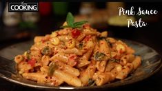 a plate full of pasta and vegetables on top of a table with the words cooking pink sauce pasta