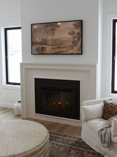 a living room with white furniture and a fireplace