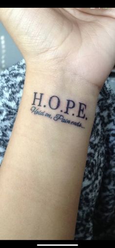 a woman's wrist tattoo with the words hope written in cursive font