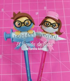 two pencils that are sitting on top of each other in front of a pink background