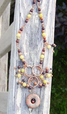 "These beautiful semi-precious gemstones remind me of the fruits that grow wild around my home and ripen in the Fall; luscious apples, grapes and berries. The beads are carefully strung on pure copper head pins and accented with bright copper findings.   Beads include: Chinese Unakite 30mm doughnut Autumn Jasper 4 & 6 mm  Brecciated Jasper 4 & 6 mm  Yellow Serpentine 8 mm (aka Butter Jade) Garnet 4 mm 1527 Earrings - Copper findings, Sterling Kidney Wires 1613 Necklace - 20\" + 2\" focal, copper findings, toggle clasp Ring 1922 - Size 7.75 - One Stone, Autumn Jasper, Copper wire 1923 - Size 8 - Three stones, Grey Feldspar, Copper wire Thanks & Blessings" Earthy Wire Wrapped Dangle Jewelry, Earthy Dangle Jewelry For Jewelry Making, Nature-inspired Round Gemstone Beads Jewelry, Earthy Green Wire Wrapped Jewelry, Nature-inspired Dangle Gemstone Jewelry, Earthy Style Jewelry With Natural Round Stones, Earthy Jewelry With Natural Stones, Earthy Natural Stones Jewelry, Nature-inspired Multicolor Round Jewelry