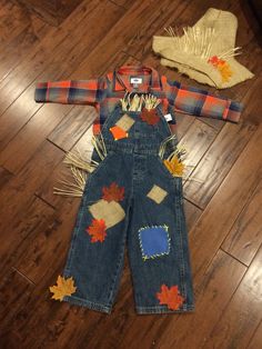 a child's overalls and hat laying on the floor