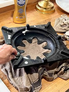 a person is painting a metal object on a table