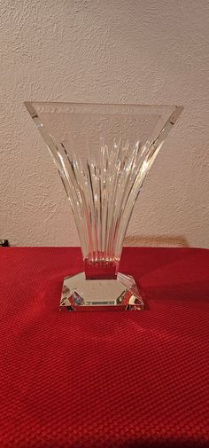 a clear glass vase sitting on top of a red table cloth