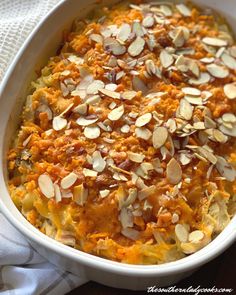 a casserole dish with carrots, almonds and other toppings in it