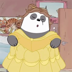 a panda bear dressed in a yellow dress standing next to a cat on a bed