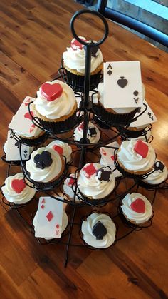 several cupcakes are arranged on a stand with playing cards and ace's symbols