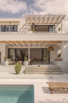 a house with a pool in front of it and some plants on the outside wall