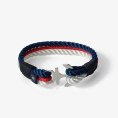 Dive into the depths of style with the Oceanic Fusion Nautical Rope Bracelet. This striking accessory captures the essence of the sea and adds a touch of sophistication to your look. It features two twisted nautical ropes, one in a vibrant blue and the other in a pristine white, seamlessly intertwined with a sleek, slender braided rope in a deep, alluring red. Crafted with precision, the Oceanic Fusion Nautical Rope Bracelet is made to order, ensuring a perfect fit for any wrist size. The stainless steel clasp adds a hint of elegance, symbolizing your resilience and determination as you navigate the currents of life.  Embrace the harmonious fusion of style and strength with the Oceanic Fusion Nautical Rope Bracelet. Whether you're exploring the shores or making a statement in the city, thi Silver Nautical Bracelets As A Gift, Nautical Blue Bracelets As A Gift, Nautical Blue Bracelets For Gifts, Nautical Anchor Bracelets As Gift, Blue Nautical Bracelets As Gifts, Blue Nautical Bracelets For Gift, Nautical Anchor Bracelet As Gift, Blue Nautical Style Bracelet For Gift, Nautical Anchor Bracelet Gift