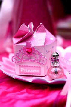 a small pink princess bottle next to a paper box