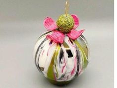 a glass ornament with a pink flower on top