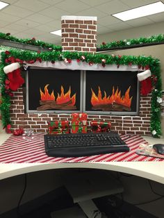 an office cubicle decorated for christmas with fireplaces and presents on the desk,