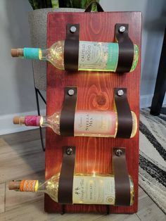 a wine rack made out of wood with three bottles on it and two corks in the middle