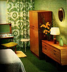 a bedroom with green walls and curtains, a dresser in the corner next to a bed