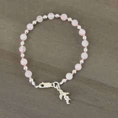 💜Pink rose quartz beads alternate with small hot pink seed beads and sterling silver spacer beads. 💜Sterling silver lobster claw clasp. 💜Small sterling  silver angel charm. 💜Pink and silver in color. 💜8 in/20.32 cm in length. 💜Rose Quartz is connected to the upper 4 chakras. Promotes compassion, forgiveness, and calm. Helps clear stored anger and resentment. 💜Link below to view all bracelets in my shop. https://www.etsy.com/shop/HisHandsJewerly?section_id=35856291 💜This bracelet comes with a purple velvet protective pouch. Adjustable Pink Beaded Bracelet With Silver Beads, Adjustable Pink Charm Bracelet With Spacer Beads, Pink Beaded Rosary Bracelet With Round Beads, Sterling Silver Beaded Charm Bracelet With Round Beads, Pink Sterling Silver Crystal Bracelet As A Gift, Sterling Silver Crystal Bracelet With Round Beads, Pink Beaded Rosary Bracelet, Spiritual Pink Charm Bracelet With Round Beads, Adjustable Silver Rosary Bracelet With Gemstone Beads