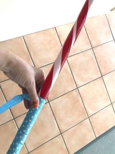 a person is holding a toothbrush in their hand on the tiled floor with tile