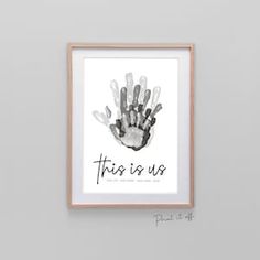 a hand print with the words family in black and white, hanging on a wall