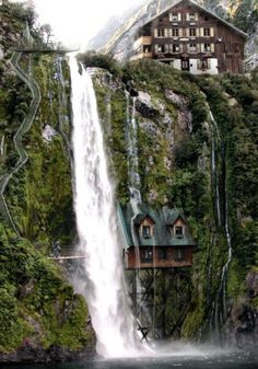 a house on top of a waterfall next to a body of water