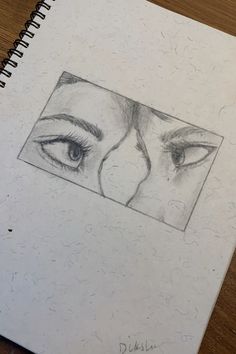 a pencil drawing of two eyes on top of a piece of paper