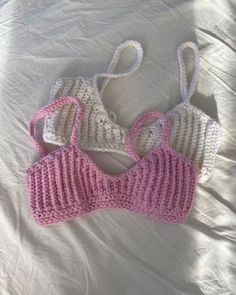 two crocheted bras laying on top of a bed