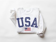 USA Sweatshirt, America Shirt, 4th Of July Shirt Women, USA Shirt, Women Military, Patriotic Shirt, Women Sweatshirt, 4th of July Party Outfit, USA Outfit, 4th of July Sweatshirt, USA shirt, Womens 4th of July, America Shirt, 4th of July, Patriotic Shirt, Red White and Blue, 4th of July Pullover Our trendy U.S. grown cotton unisex crewneck sweatshirts are made to order and are designed, printed, pressed and shipped from us to you! The fabric is a 50/50 blend and printed using eco-friendly water-based inks resulting in super comfy sweatshirts with soft, breathable prints that last over time. 📏 Sizing  All of our sweatshirts are unisex and fit great on both men and women. Please take a look at our sizing chart included in the images for measurements. 📋 Production & Shipping Time ► Producti Long Sleeve Tops For 4th Of July, Long Sleeve Cotton Tops For 4th Of July, Cotton Long Sleeve Top For 4th Of July, Patriotic American Flag Long Sleeve Tops, White Crew Neck Sweatshirt For 4th Of July, Casual White Sweatshirt With American Flag Print, Independence Day Cotton Sweatshirt With Letter Print, Independence Day Cotton Letter Print Sweatshirt, 4th Of July Cotton Crew Neck Sweatshirt