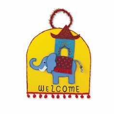 a welcome sign with an elephant on it's back and red pom poms around the edges