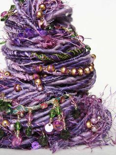 a stack of purple and gold jewelry on top of each other