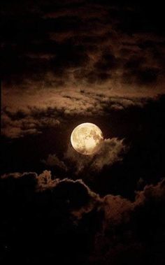 the full moon is shining brightly in the dark night sky with fluffy clouds around it