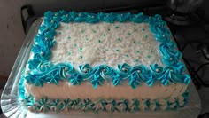 a cake with blue and white frosting sitting on top of a metal sheet pan