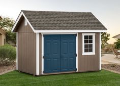 a blue and white shed sitting in the grass