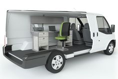 the interior of a white van with green seats and desks in front of it