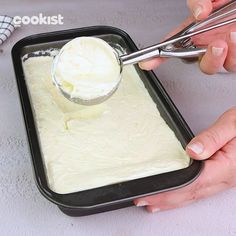 someone is spreading icing on top of the cake batter in a pan with tongs