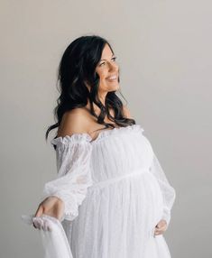 a woman in a white dress posing for the camera