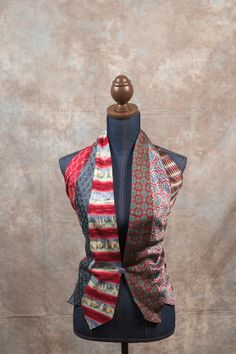 a mannequin wearing a multicolored scarf on top of a dress form