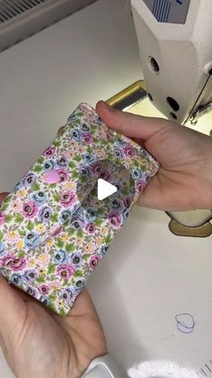 a person is using a sewing machine to sew flowers on a piece of fabric