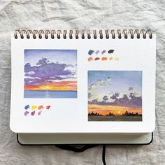 an open notebook with watercolors on it and the pages are lined in different colors