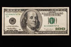 an american one hundred dollar bill on a black background