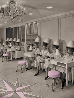 a group of women wearing hats sitting at desks