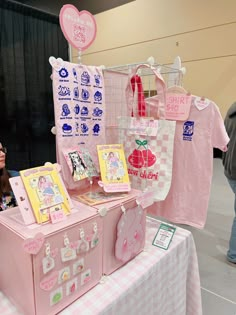 a woman standing next to a pink trunk on top of a checkered cloth covered table