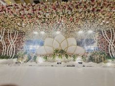 an elaborate floral display in the middle of a room filled with flowers and greenery