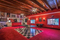 a ping pong table in the middle of a room with red walls and checkered flooring