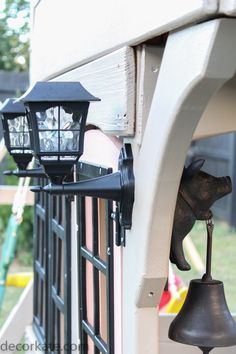 two lights on the side of a building with an elephant figurine next to them